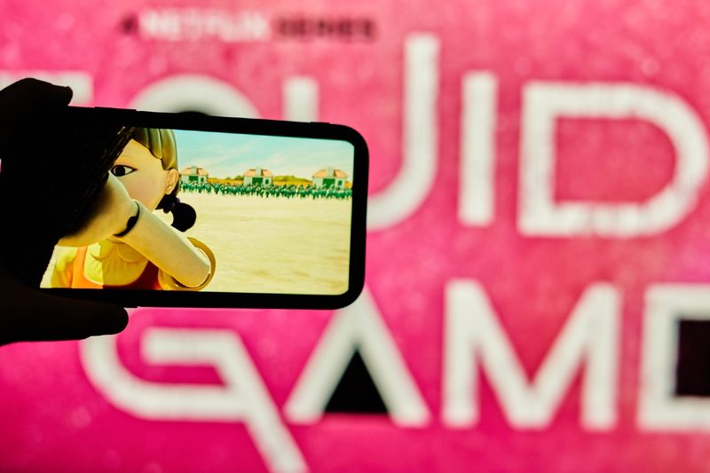 Watching Netflix series Squid Game on cell phone.