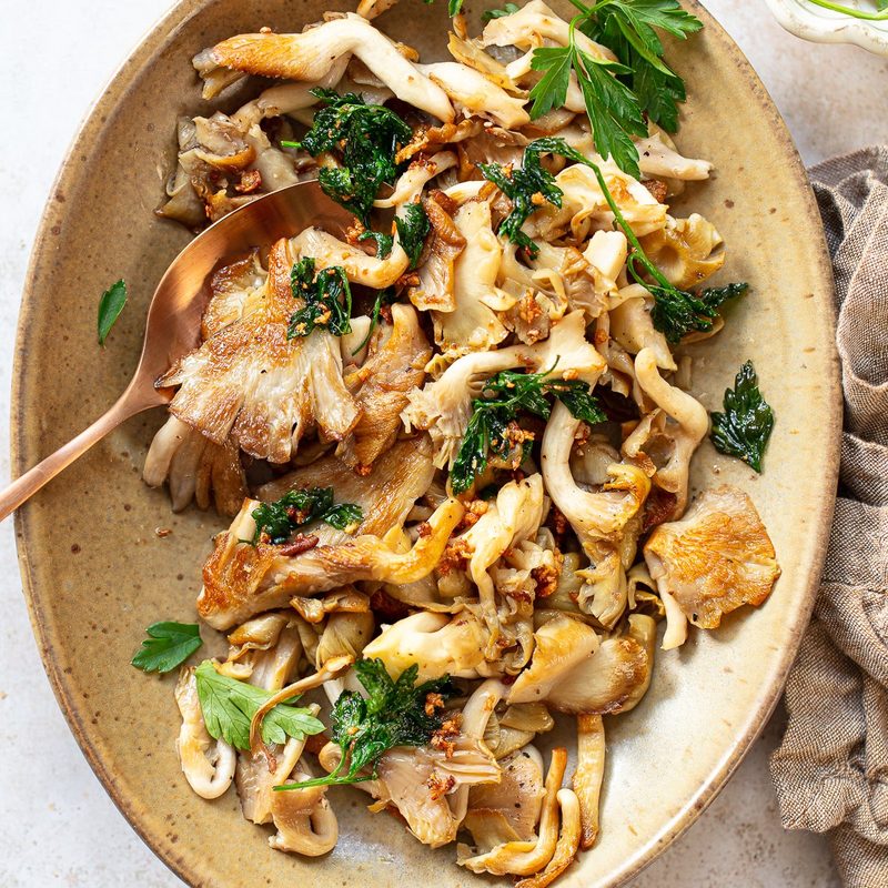 A plate of food with oyster mushrooms cooked in it.