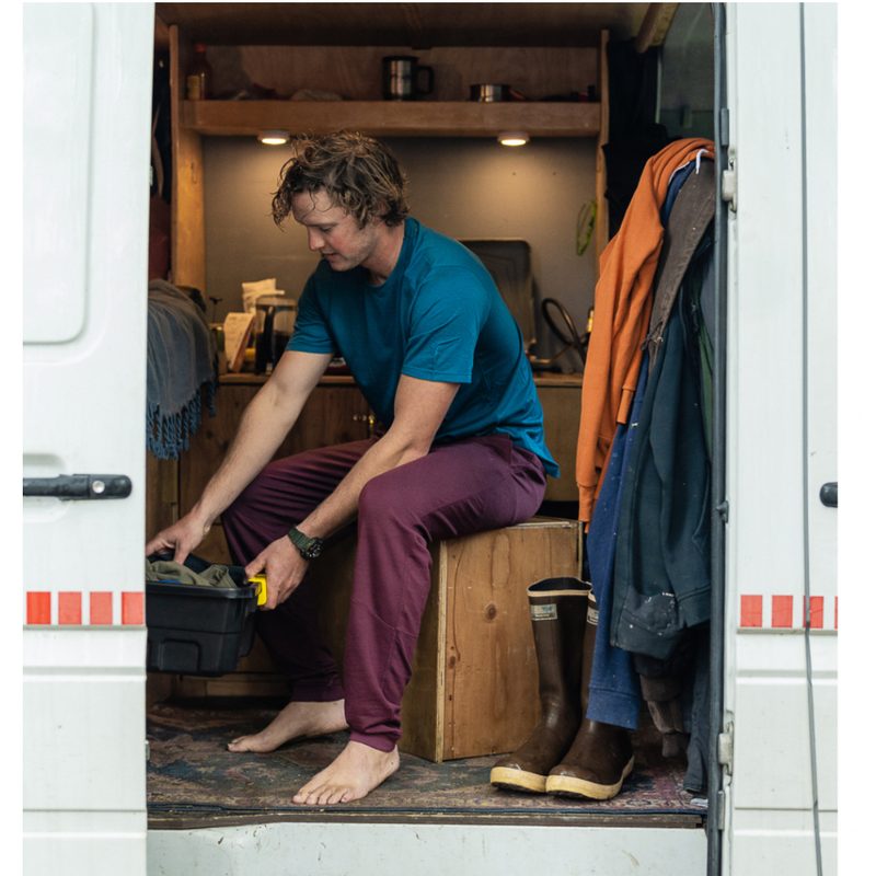 A man sitting in his van in a pair of maroon Ibex Nomad Joggers