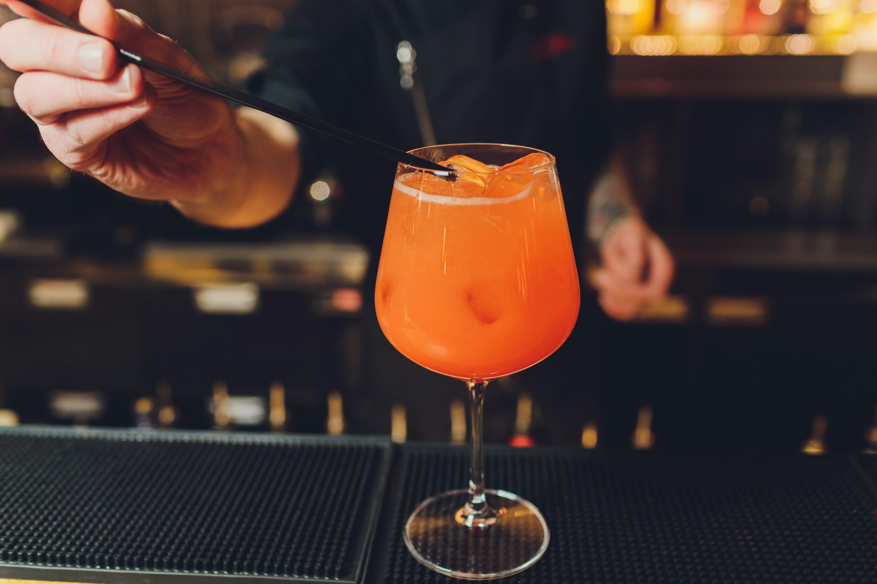 Bartender adding ingredients to a cocktail