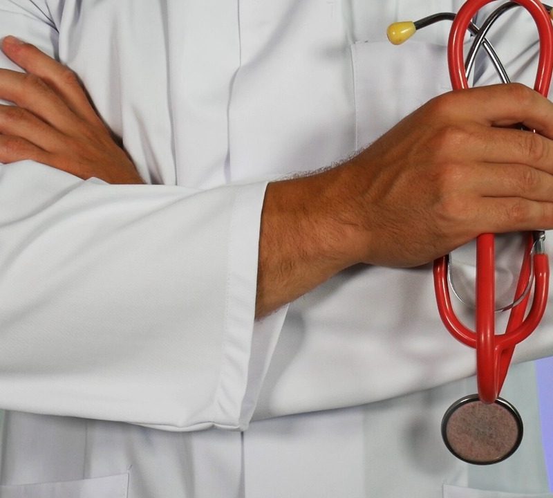 arms of doctor with red stethoscope