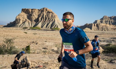 A man runs through the desert on a trail running event.
