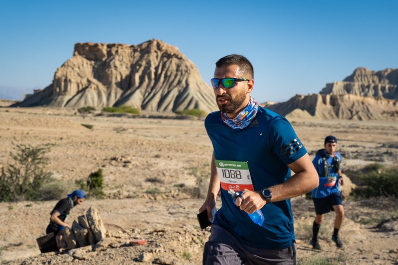 A man runs through the desert on a trail running event.