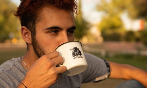 Man drinking coffee outside.