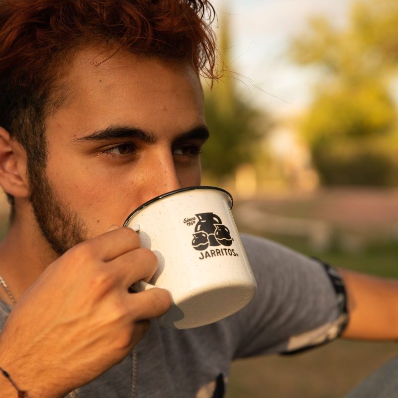 Man drinking coffee outside.