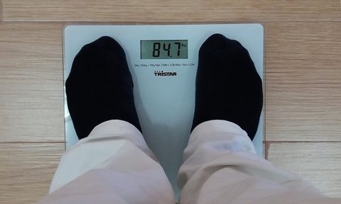 Man standing on a body fat scale.