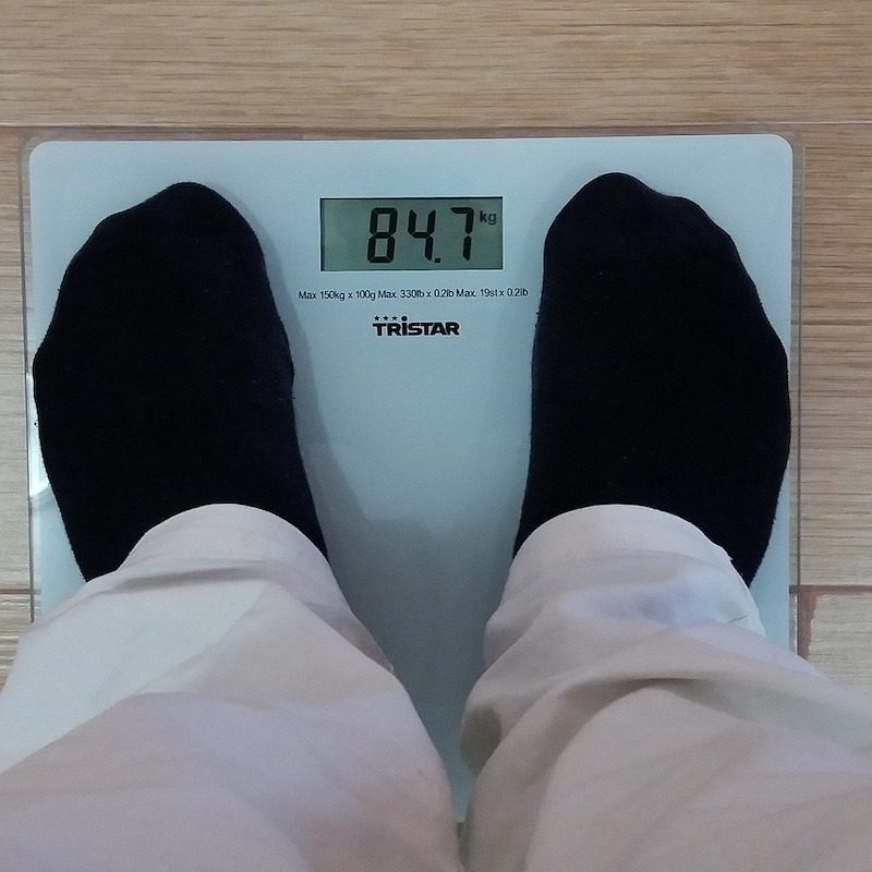 Man standing on a body fat scale.