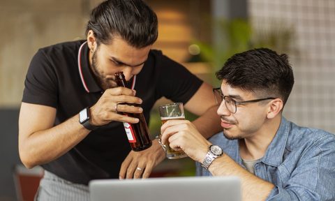 two men drinking beer at work