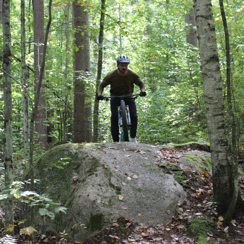 Mountain biker climbing the granite boulders of the Nicolet Roche trail in Wisconsin.