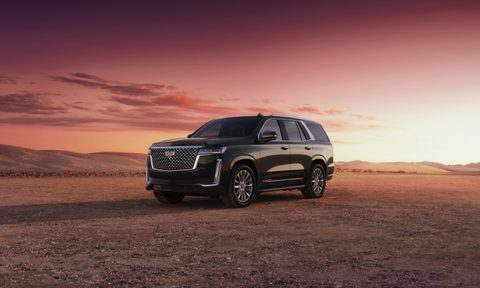 2023 Cadillac Escalade on a dirt mountain with the sun setting in the back.