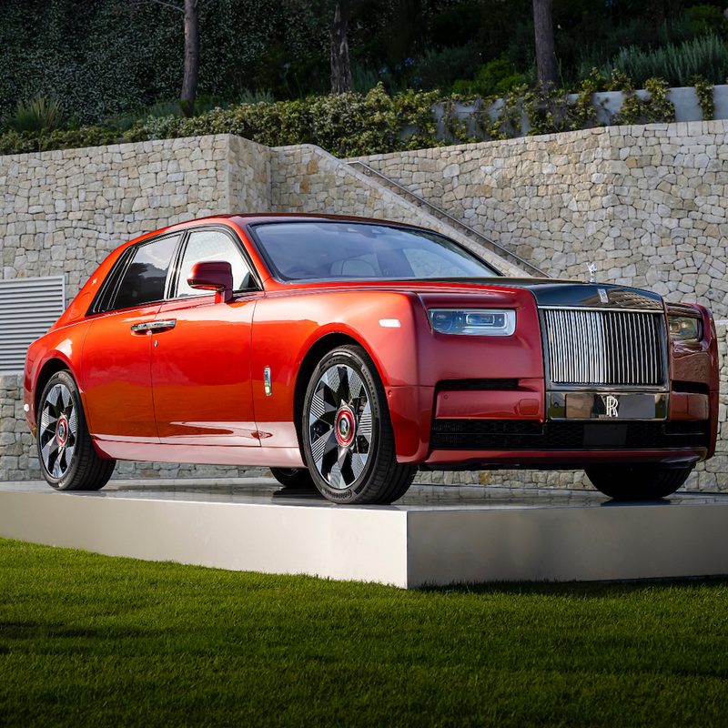 2023 Rolls-Royce Phantom sitting on a platform on green grass in front of a stone wall.