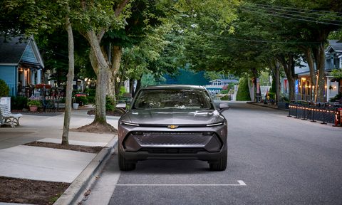 Front end of 2024 Chevrolet Equinox EV 1LT on a street with trees in the back.