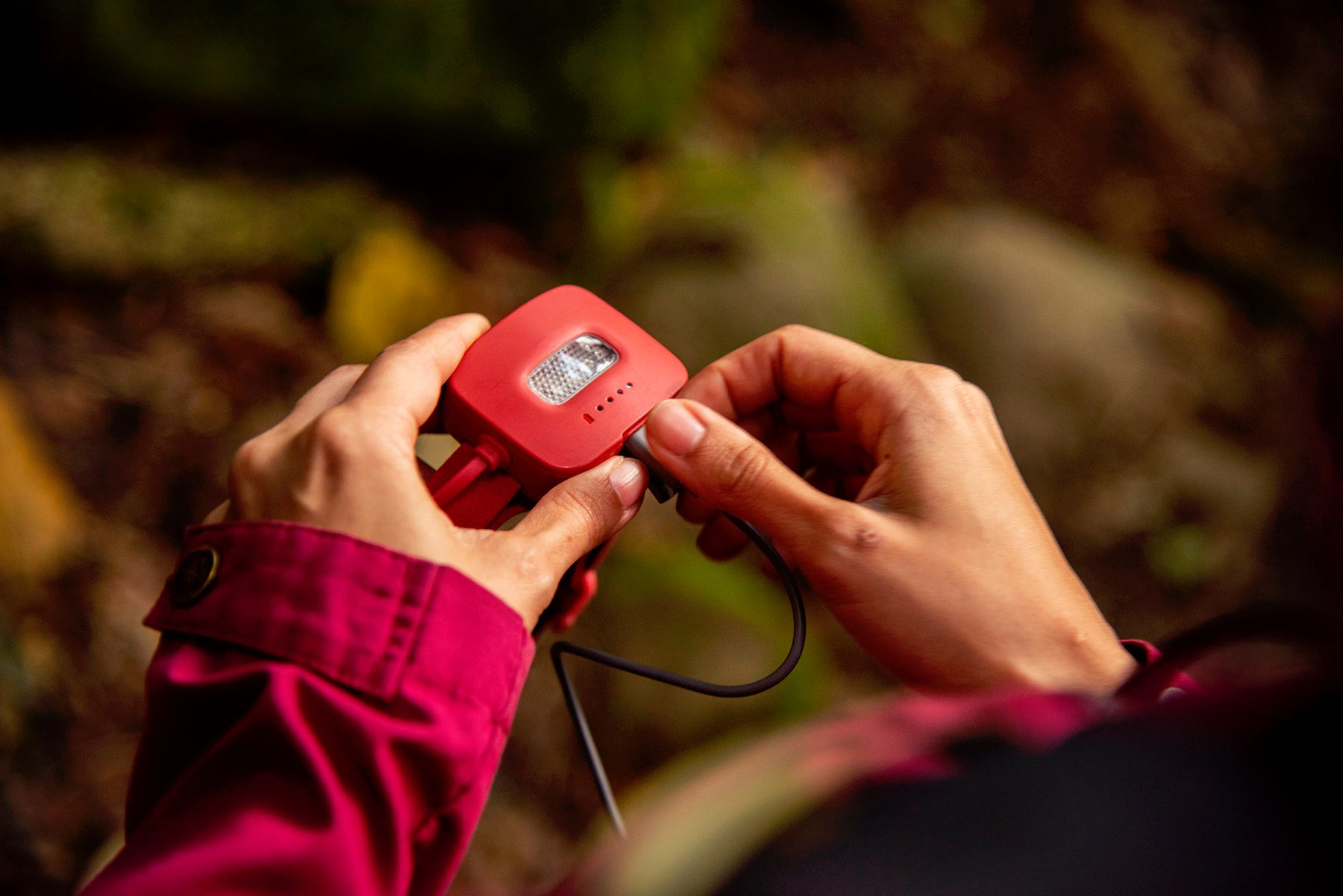 Plugging a charging unit into the rear of the BioLite HeadLamp 425