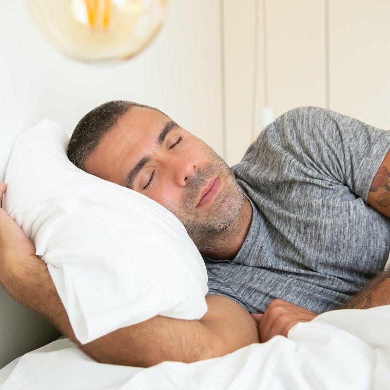 a man sleeping on white bedding