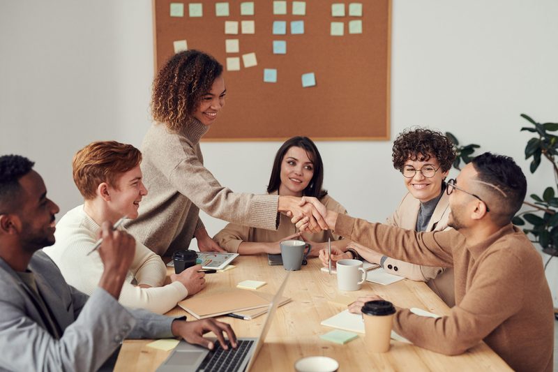 group of workers shaking hands and supporting each other