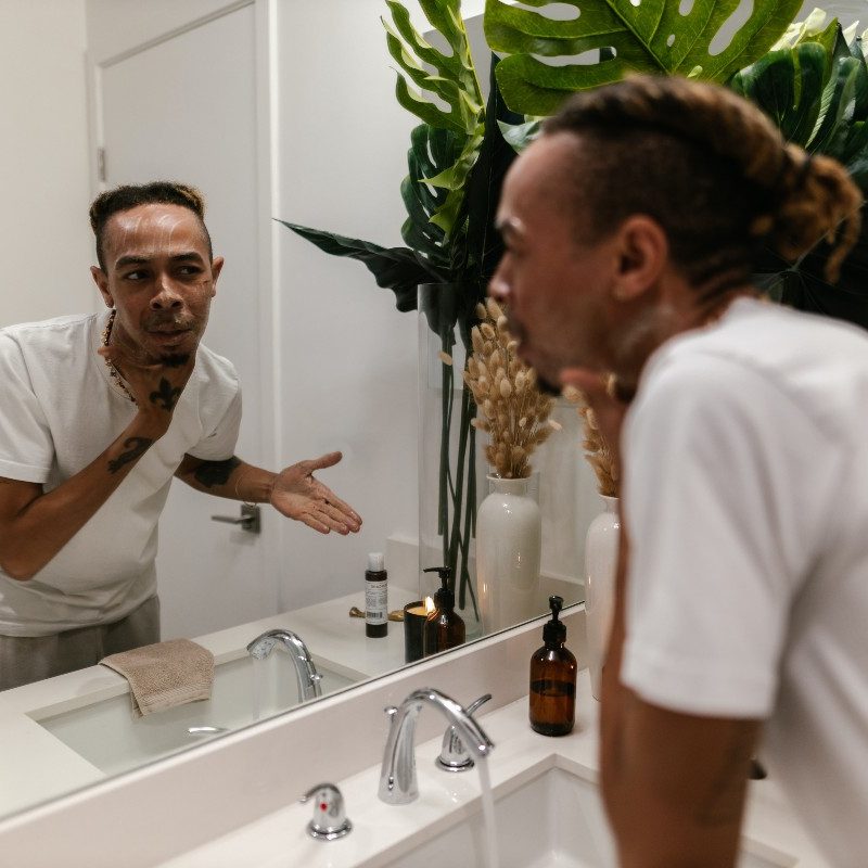 A man applying skincare products in the bathroom
