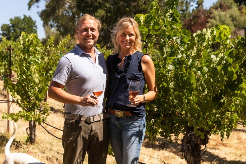 The Skupny's enjoying wine in the vineyard.
