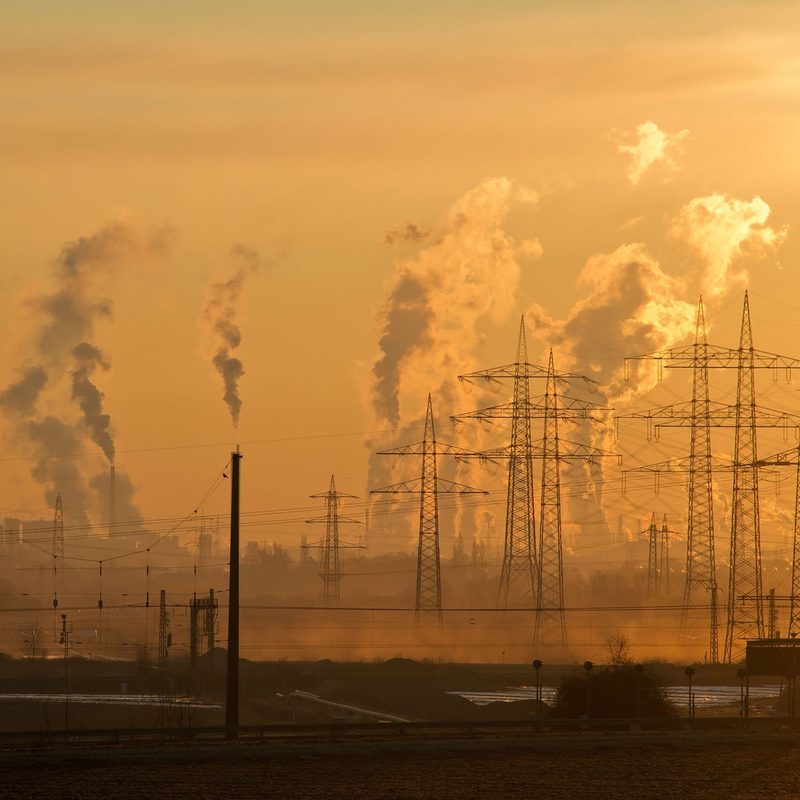 smog filling the air behind wires against an orange sky