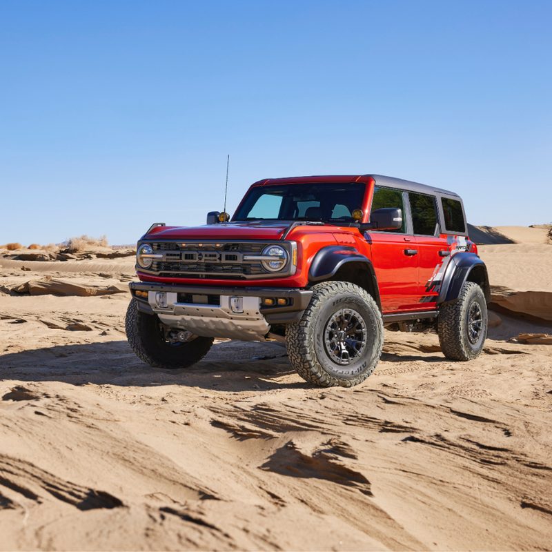 2022 Ford Bronco Raptor front end angle from driver's side in sand dunes.