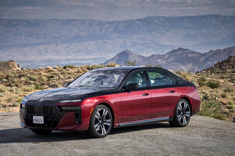 2023 BMW 7-Series parked on the side of the road in front of mountains.