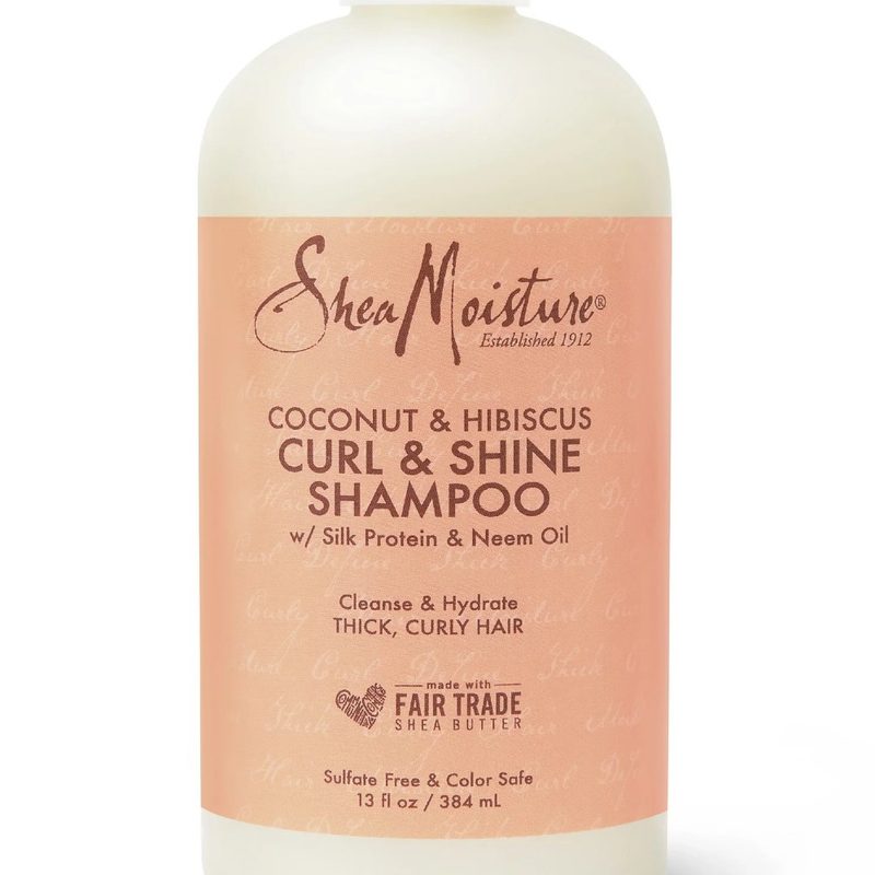 A close-up of a bottle of SheaMoisture Coconut and Hibiscus Curl and Shine Shampoo.