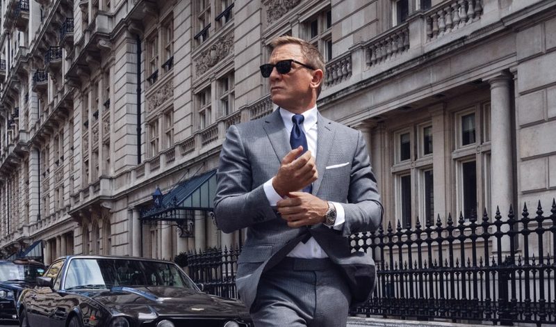 James Bond in gray suit fixing cuffs