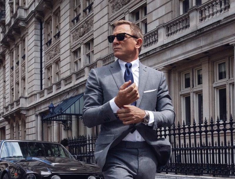 James Bond in gray suit fixing cuffs
