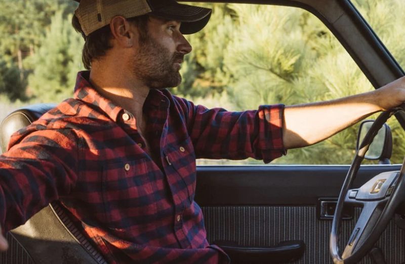 Man in a flannel shirt driving a truck