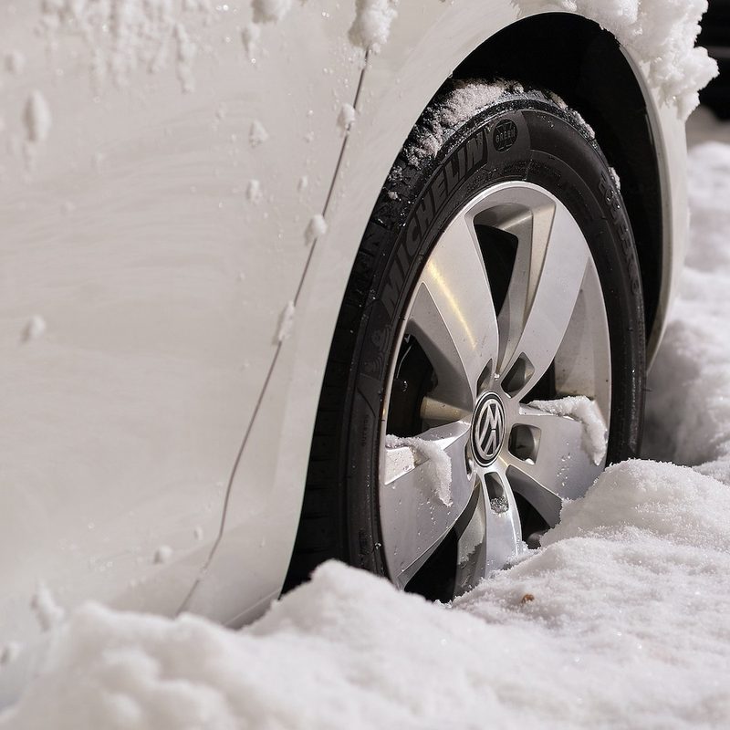 White Volkswagen car in deep snow with winter tires on.