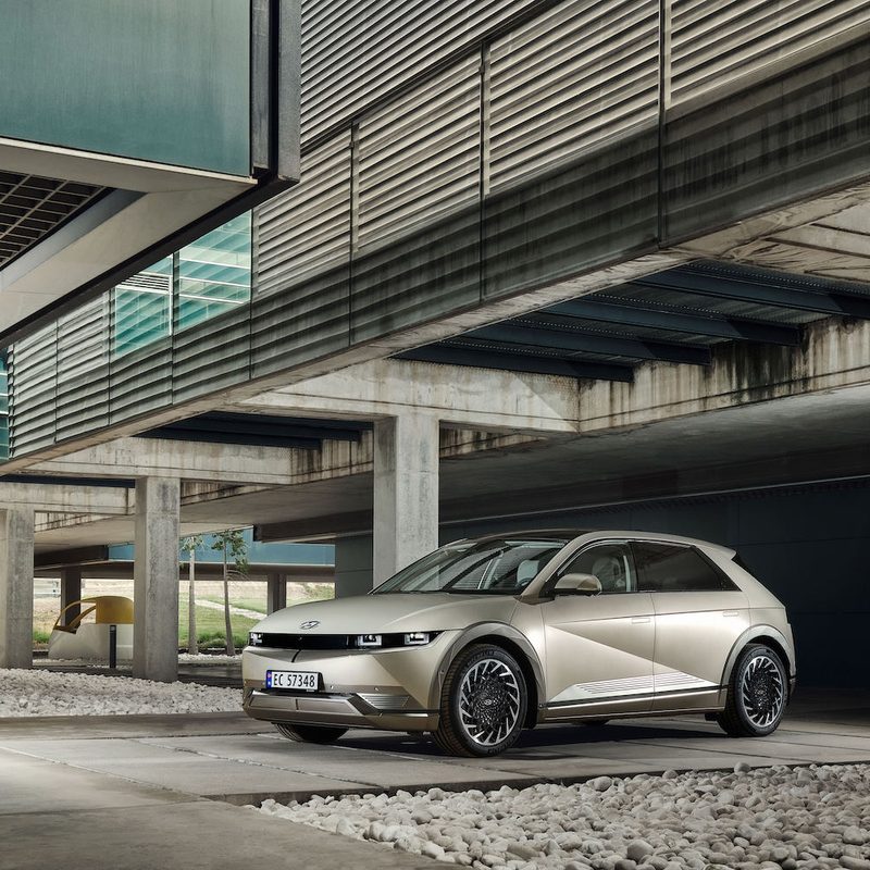 Hyundai Ionic 5 parked in a parking structure with concrete walls and large windows on concrete.