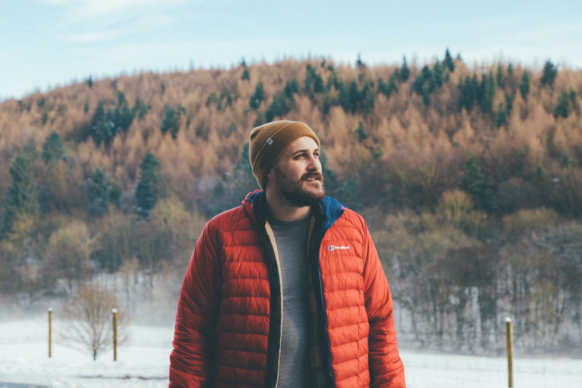 Man in a red puffer jacket standing outside in winter.