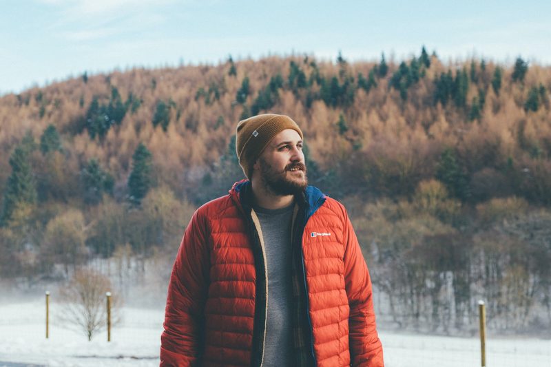 Man in a red puffer jacket standing outside in winter.