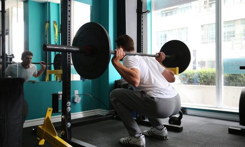 Man doing squats with a weight