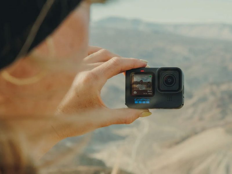 Woman taking selfie with GoPro Hero11 Black Action Camera.