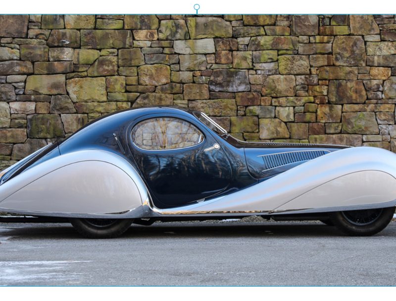 1937 TALBOT-LAGO T150-C-SS TEARDROP COUPE side profile parked in front of a brick wall.