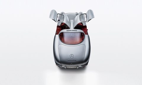 1955 Mercedes-Benz SLR “Uhlenhaut Coupé” overhead image with the gullwing doors open from behind in a white studio.
