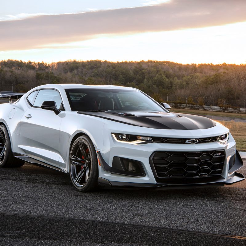 2018 Chevrolet Camaro ZL1 1LE front end angle from passenger side parked on a race track with the sun setting in the back.