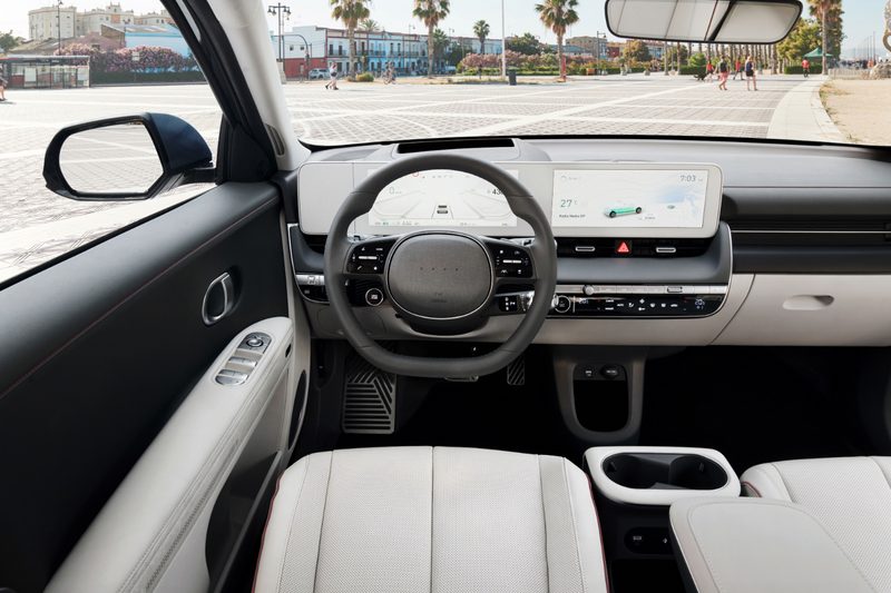 Close up of dashboard, steering wheel, and touchscreen in the 2022 Hyundai Ioniq 5 in a parking lot.