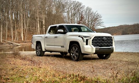 2022 Toyota Tundra Hybrid Capstone front end angle from passenger's side in front of a lake with trees in the back.