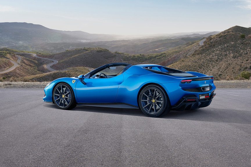 2023 Ferrari 296 GTS rear end angle with top down with mountains in the back.