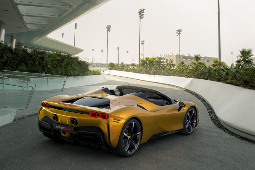 Rear end angle of 2023 Ferrari SF90 Spider with top down parked on the side of the road.