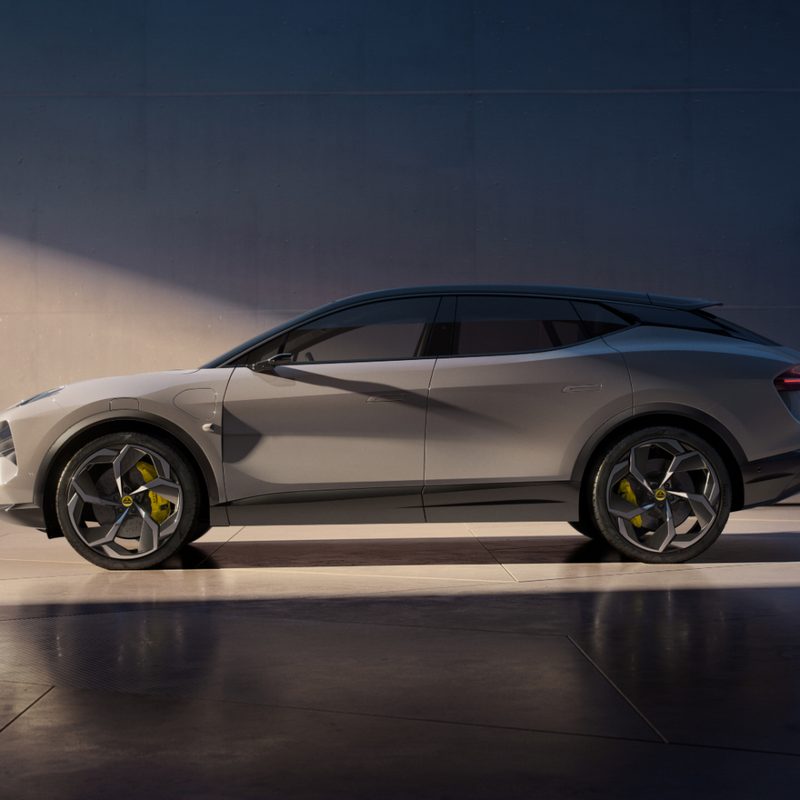 Lotus Eletre side profile in front of a wall with dramatic sunlight coming from the front.