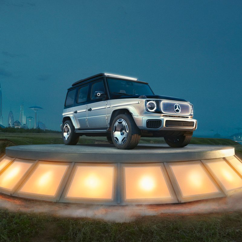 Mercedes-Benz EQG front end angle from passenger's side on a platform in front of a futuristic skyline