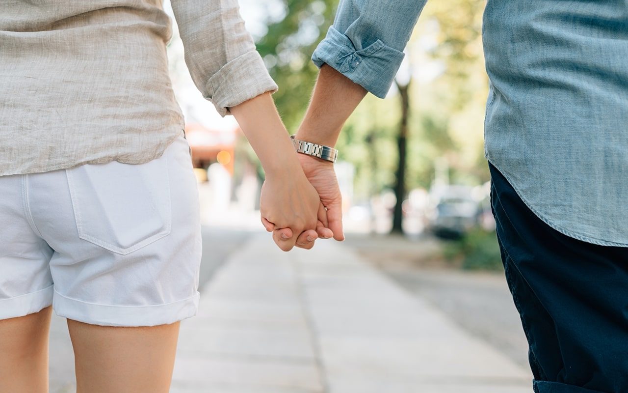 couple holding hands during the day outside