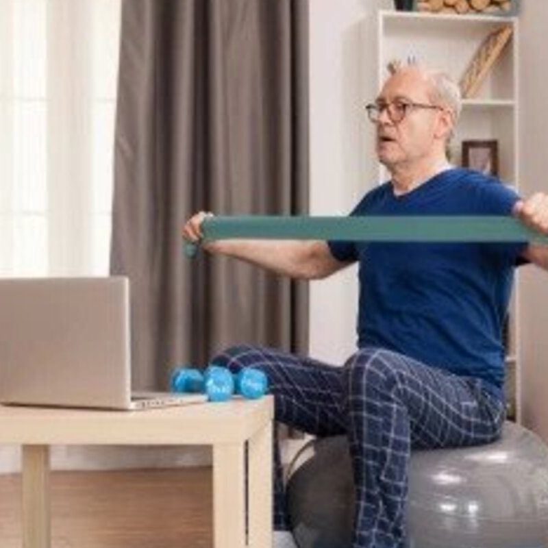 Senior man using resistance band while exercising.