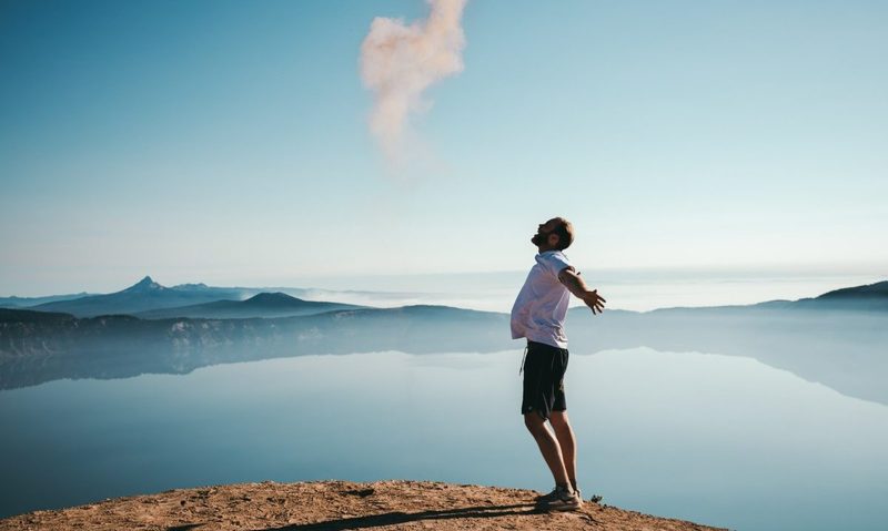 Man outside by the water: happiness
