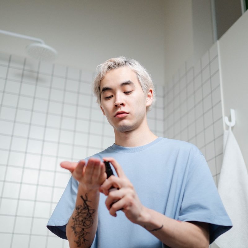 Man applying a skincare product after showering