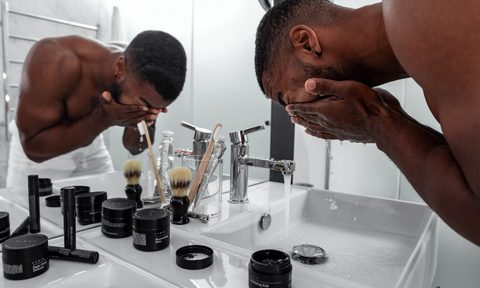 Man washing his face in the bathroom.