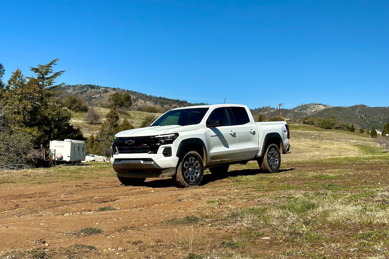 Front end angle of the 2023 Chevrolet Colorado Z71 parked in a muddy field.