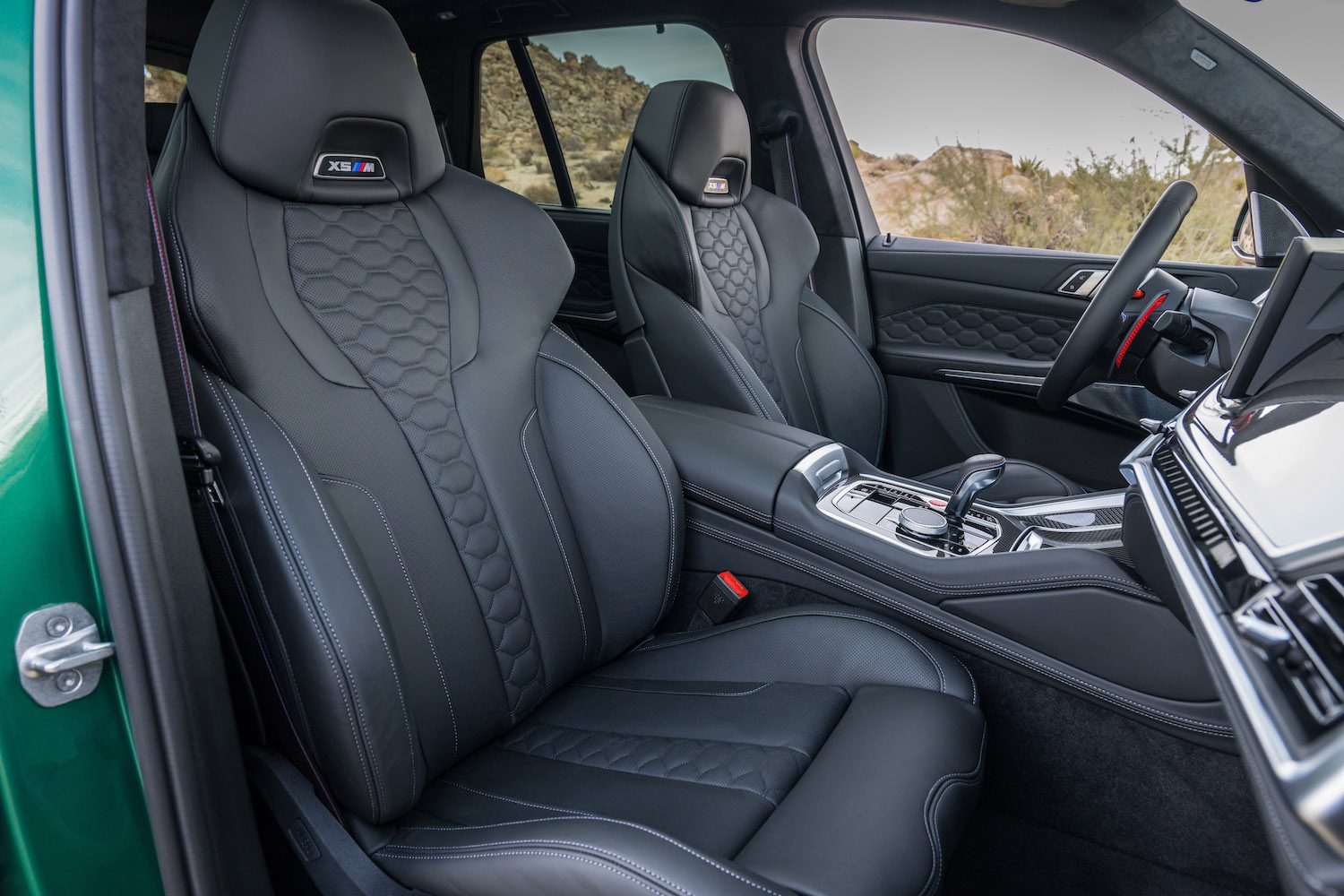 Close up of front seats in the 2024 BMW X5 M Competition with desert in the back.